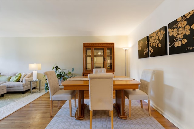 dining space with wood finished floors and baseboards