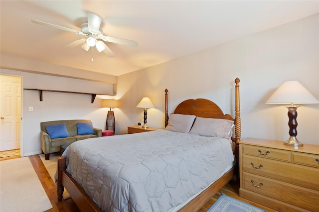 bedroom featuring a ceiling fan, baseboards, and wood finished floors