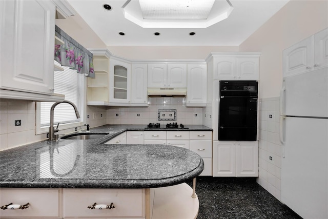 kitchen featuring white refrigerator, black gas stovetop, sink, and white cabinets