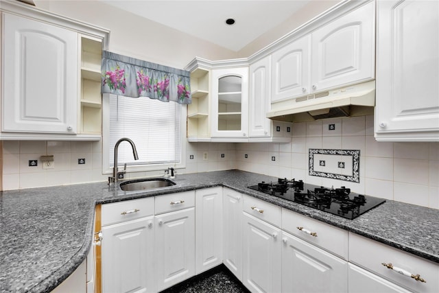 kitchen with white cabinetry, backsplash, sink, and black stovetop