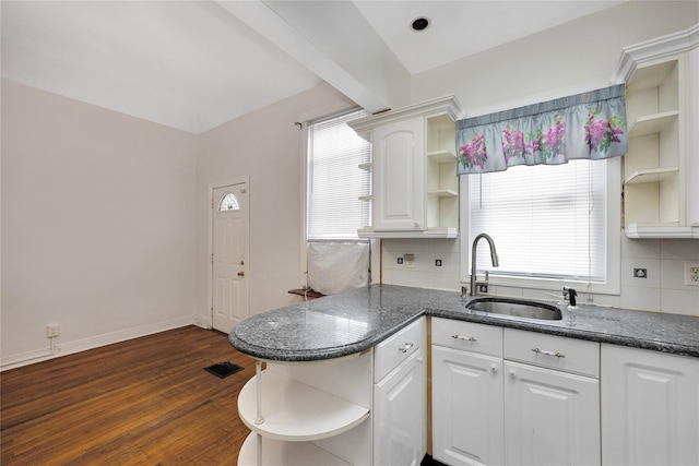 kitchen featuring white cabinetry, sink, dark wood-type flooring, and decorative backsplash