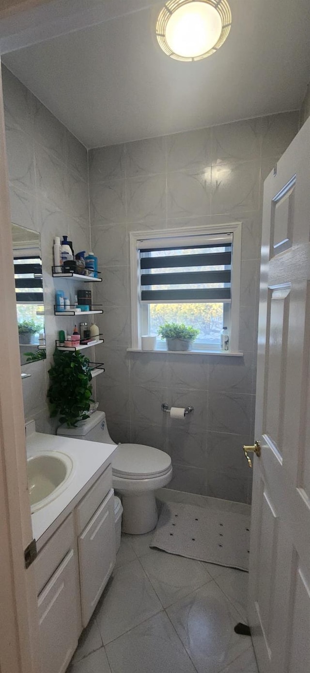 half bath featuring toilet, tile walls, and vanity