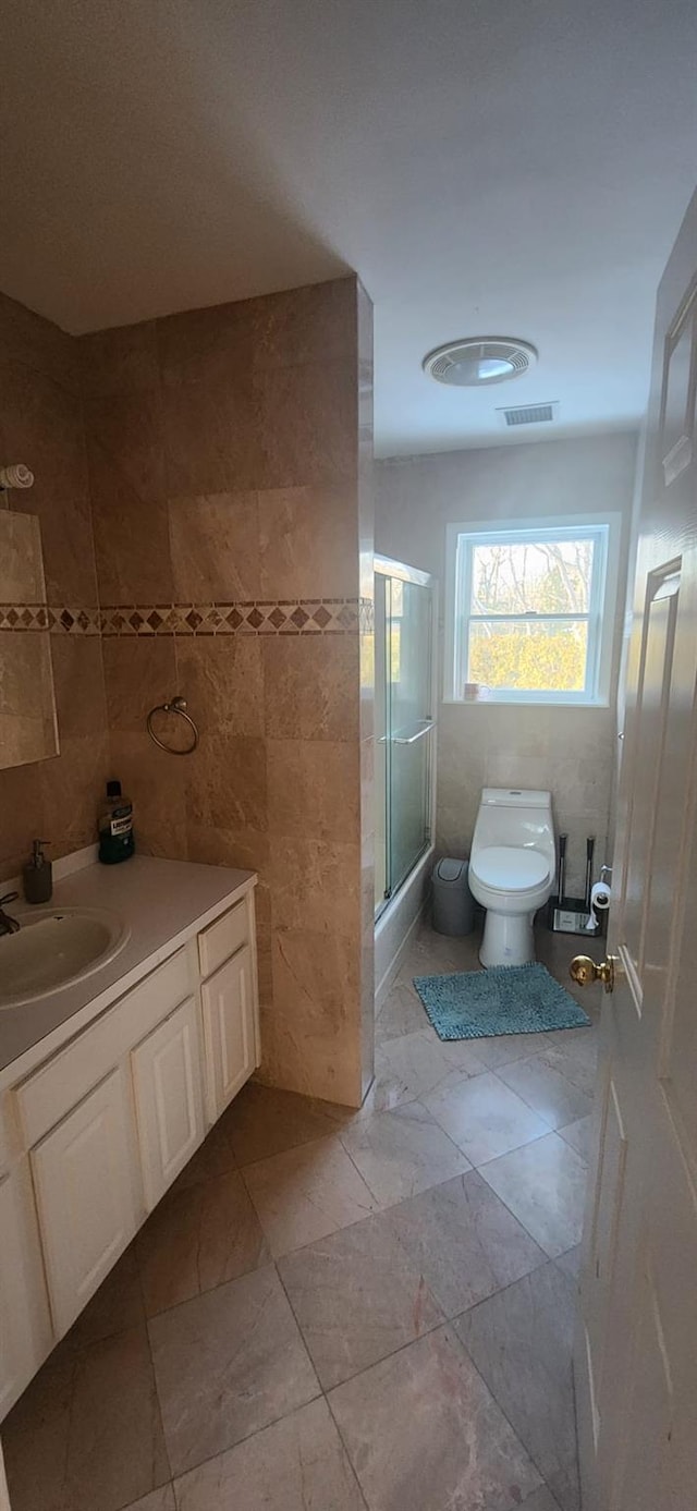 full bath featuring visible vents, toilet, tile walls, and vanity