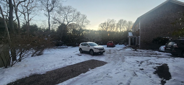 snow covered parking with a garage