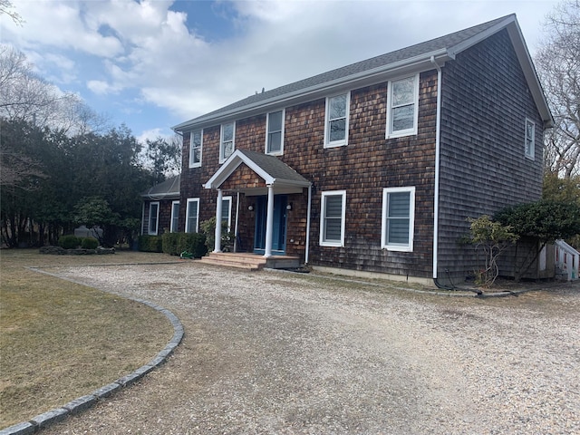 colonial home with driveway and a front lawn