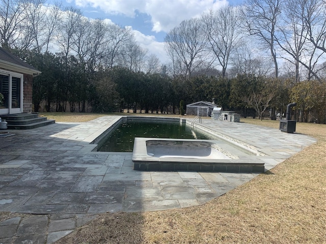 pool with entry steps, an outdoor structure, and a patio area