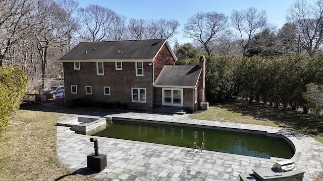 back of house with a lawn, entry steps, and a patio area