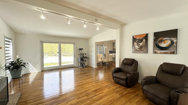 living area with light wood-type flooring and vaulted ceiling
