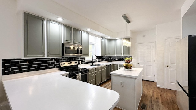 kitchen featuring visible vents, appliances with stainless steel finishes, a sink, gray cabinets, and backsplash