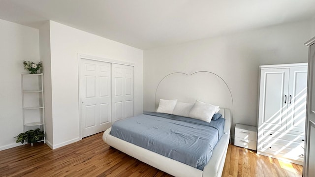 bedroom featuring a closet, baseboards, and light wood-style floors