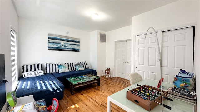 living area featuring visible vents and wood finished floors