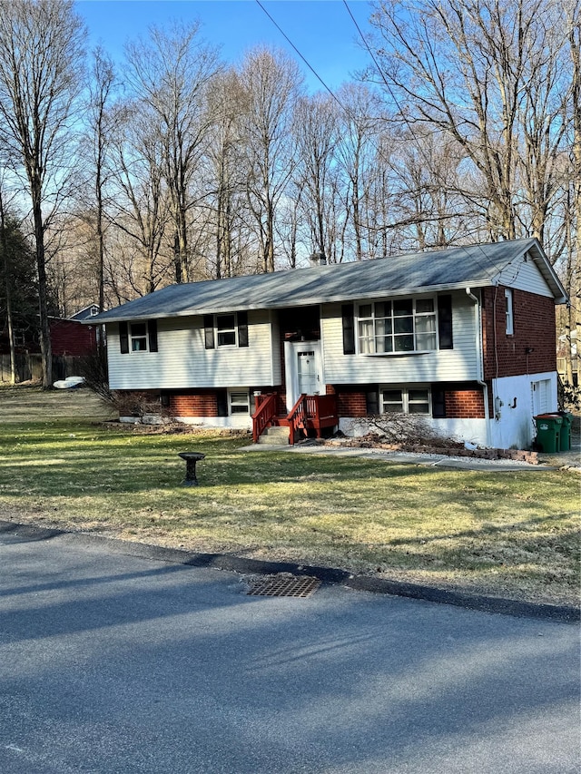 bi-level home featuring a front yard and brick siding