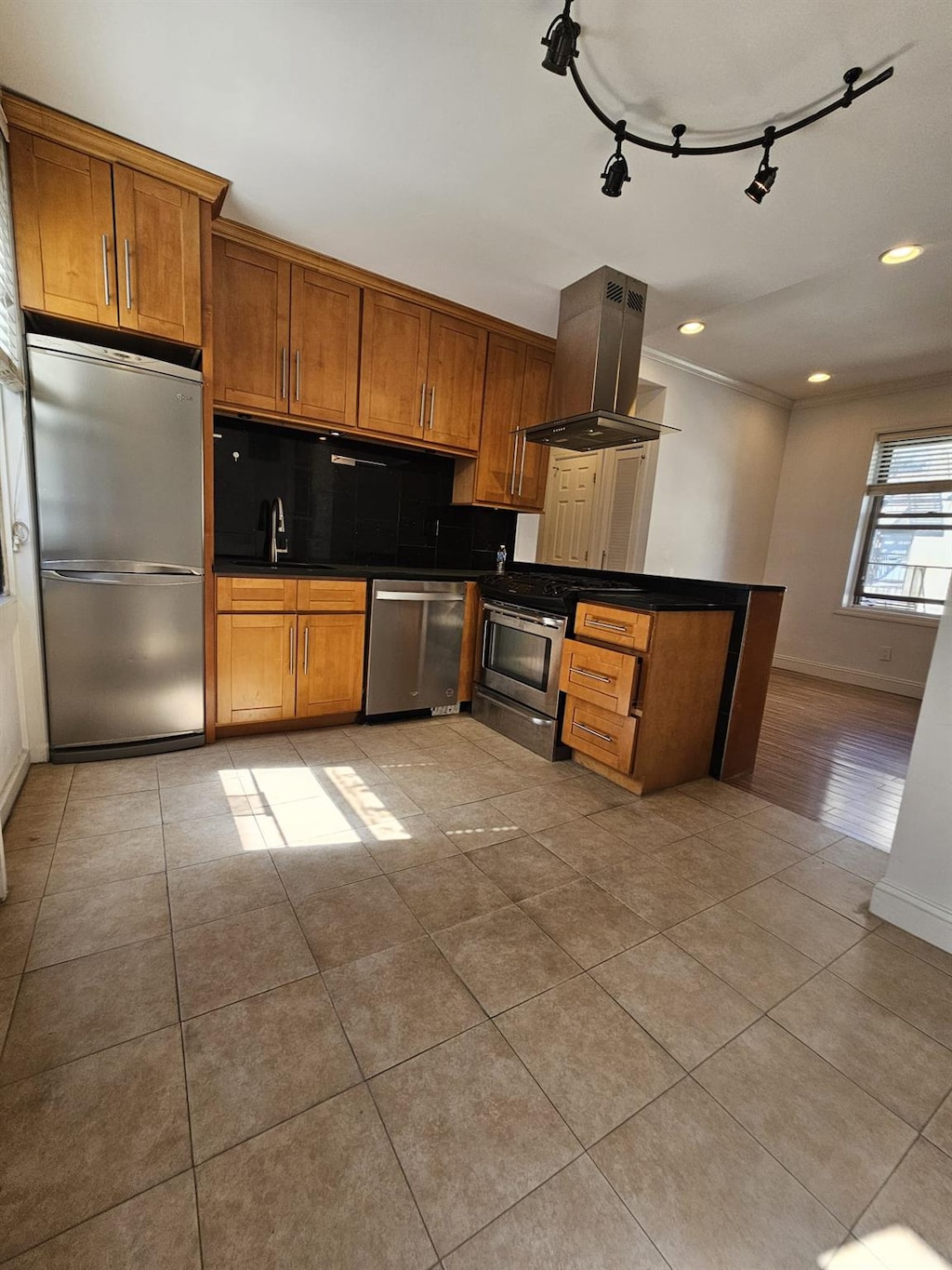 21-15 33rd St Unit 4G, Astoria, NY 11105 - kitchen featuring light tile patterned floors, sink, stainless steel appliances, tasteful backsplash, and island exhaust hood