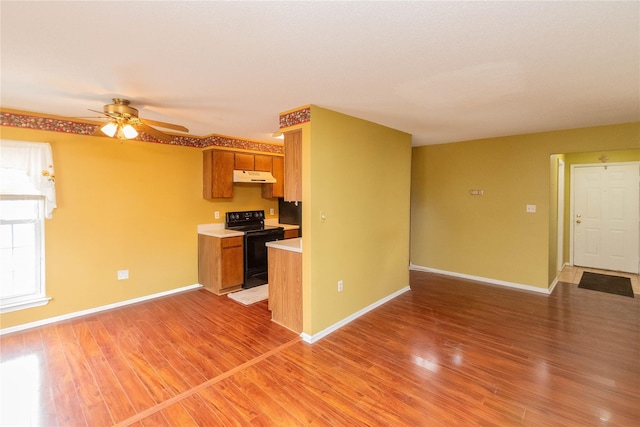 kitchen with ceiling fan, wood-type flooring, and electric range