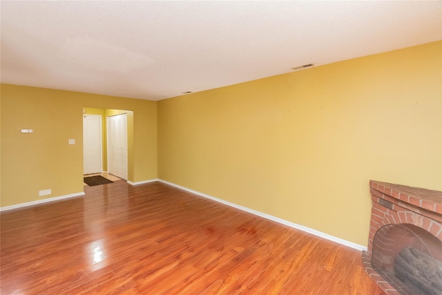 empty room featuring hardwood / wood-style flooring and a fireplace