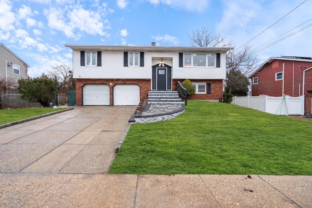 split foyer home featuring a garage and a front yard