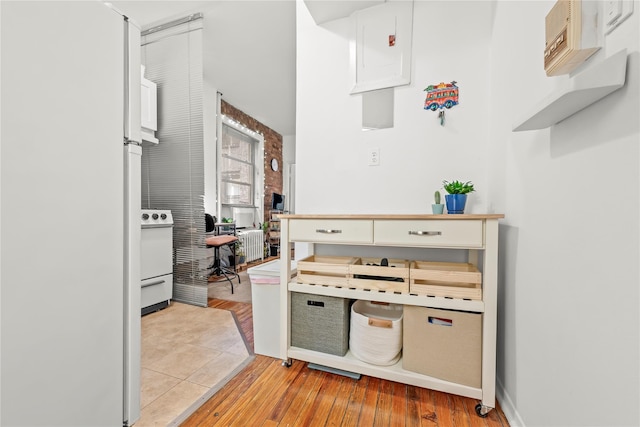 kitchen featuring range, light hardwood / wood-style flooring, and white refrigerator