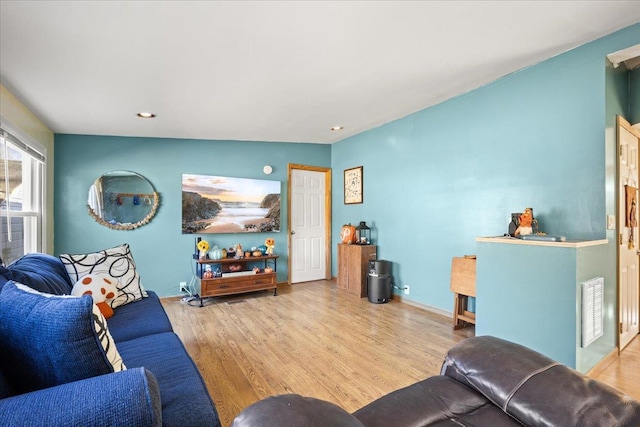 living room featuring vaulted ceiling and light hardwood / wood-style flooring