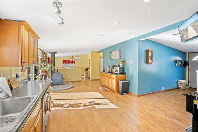 kitchen featuring light brown cabinetry, sink, stainless steel dishwasher, and light hardwood / wood-style floors