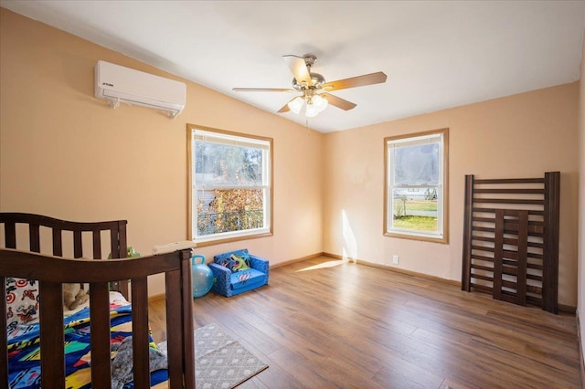 bedroom featuring ceiling fan, wood-type flooring, and an AC wall unit