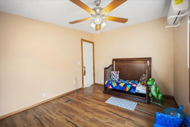 bedroom with dark wood-type flooring, ceiling fan, and a wall mounted air conditioner