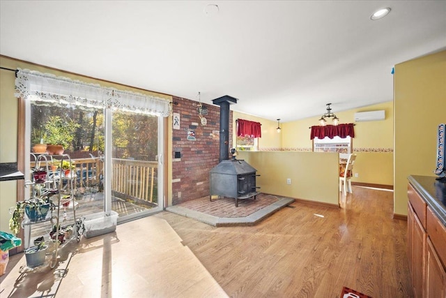 interior space featuring light wood-type flooring, a wall mounted AC, and a wood stove