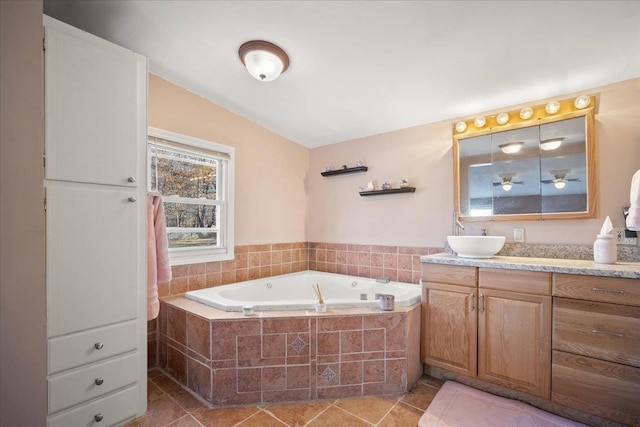 bathroom featuring vanity, tiled bath, and tile patterned flooring