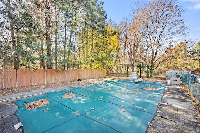 view of swimming pool with a diving board