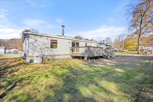 back of property featuring a lawn and a deck