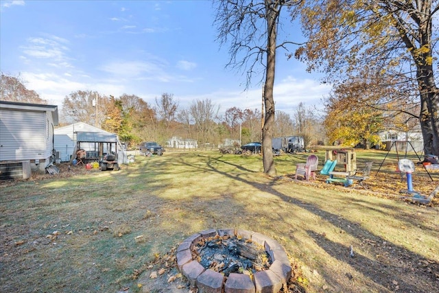 view of yard featuring a playground and a fire pit