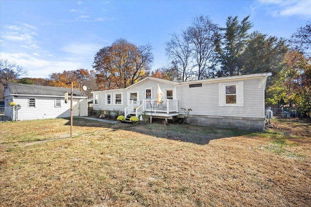 rear view of property featuring a yard and a deck