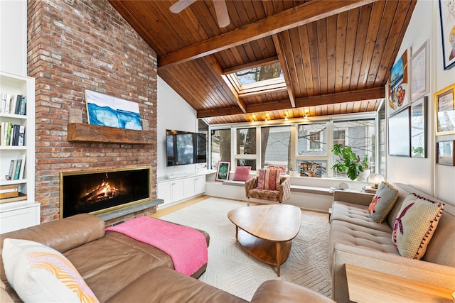 living area with vaulted ceiling with skylight, wood ceiling, and a brick fireplace