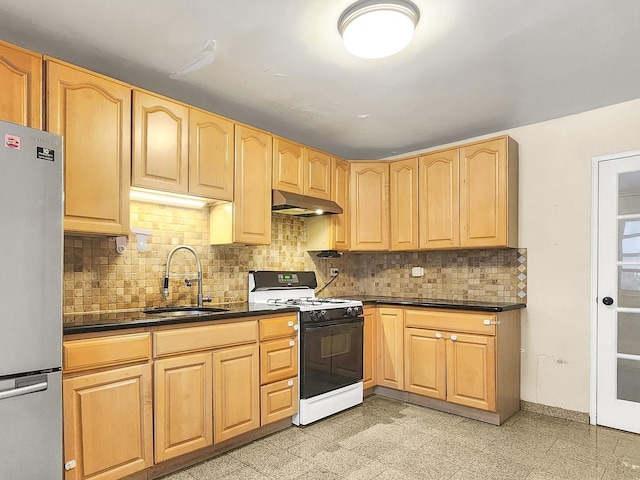 kitchen featuring tasteful backsplash, stainless steel fridge, sink, and range with gas stovetop