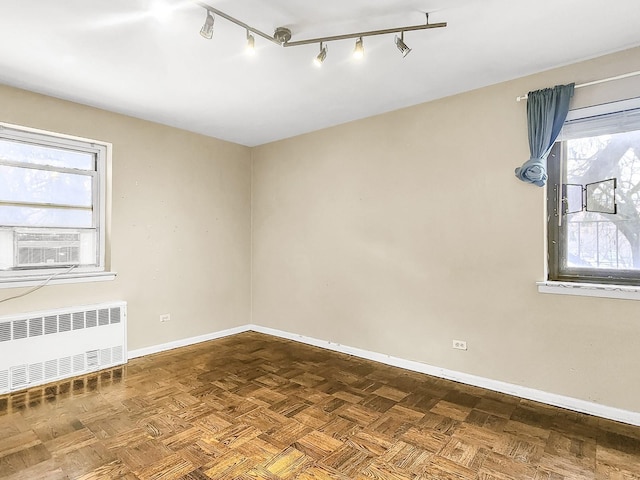 spare room featuring plenty of natural light, radiator, parquet floors, and cooling unit