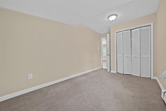 unfurnished bedroom featuring light colored carpet and a closet