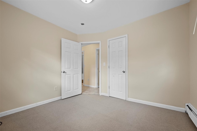 unfurnished bedroom featuring light carpet and baseboard heating