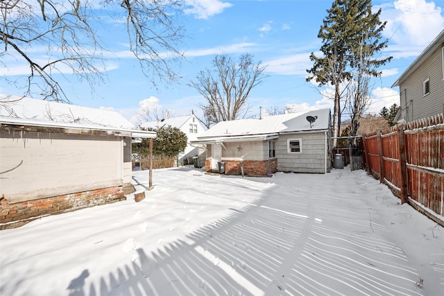 view of snow covered back of property