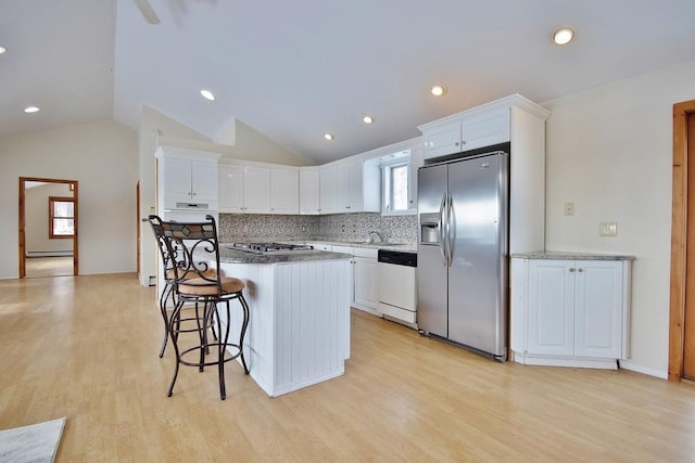 kitchen with tasteful backsplash, a kitchen island, appliances with stainless steel finishes, and white cabinetry