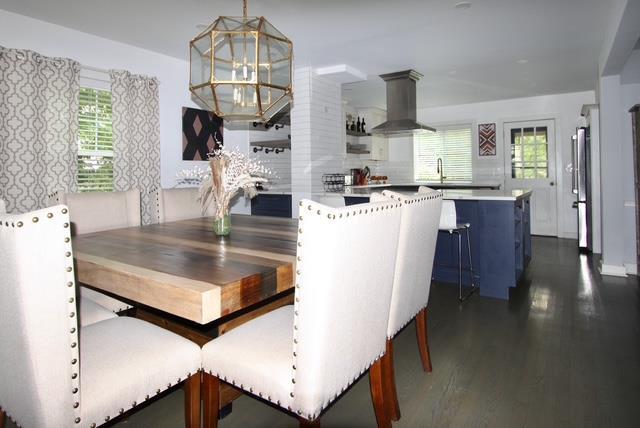 dining space with dark wood-type flooring and an inviting chandelier