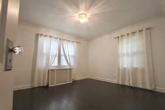 unfurnished room featuring baseboards, dark wood-type flooring, and crown molding