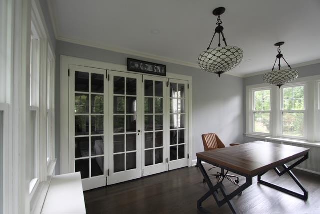 dining space with dark wood-style flooring, crown molding, and french doors