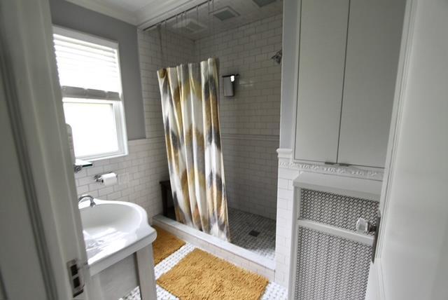 full bath featuring ornamental molding, tile patterned flooring, vanity, a shower stall, and tile walls