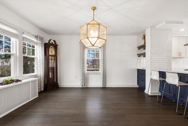 320 Putnam Ave, Port Chester, NY 10573 - unfurnished dining area featuring dark wood-style floors, baseboards, radiator heating unit, and a chandelier
