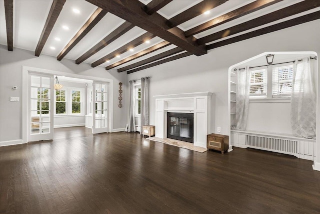 320 Putnam Ave, Port Chester, NY 10573 - unfurnished living room with dark wood finished floors, beamed ceiling, radiator heating unit, a premium fireplace, and baseboards