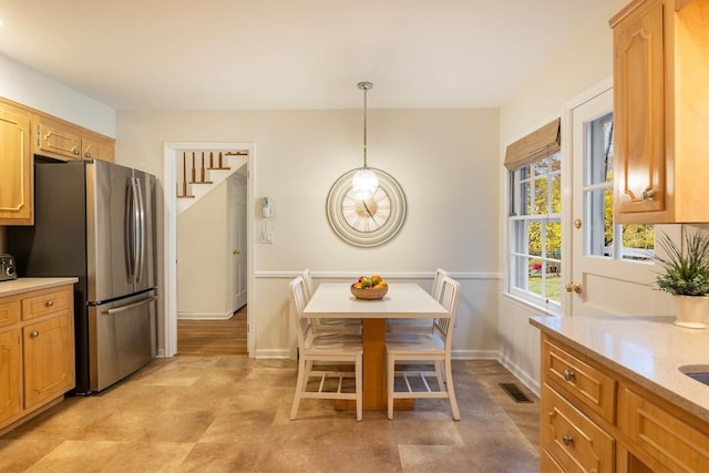 kitchen featuring pendant lighting and stainless steel refrigerator