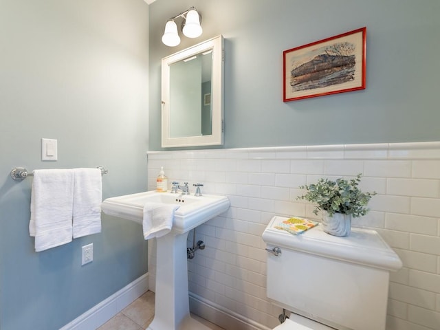 bathroom featuring toilet, tile patterned flooring, and tile walls