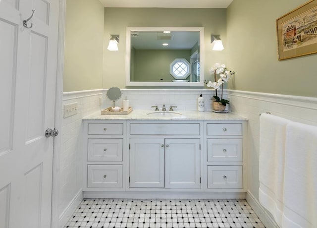 bathroom featuring vanity and tile walls