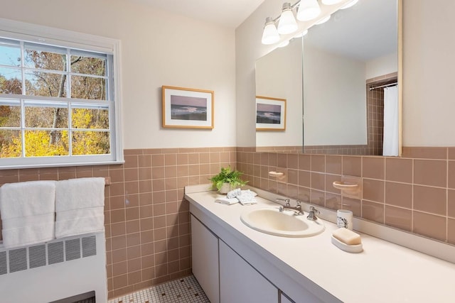 bathroom with radiator heating unit, vanity, and tile walls