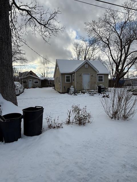 view of snow covered back of property