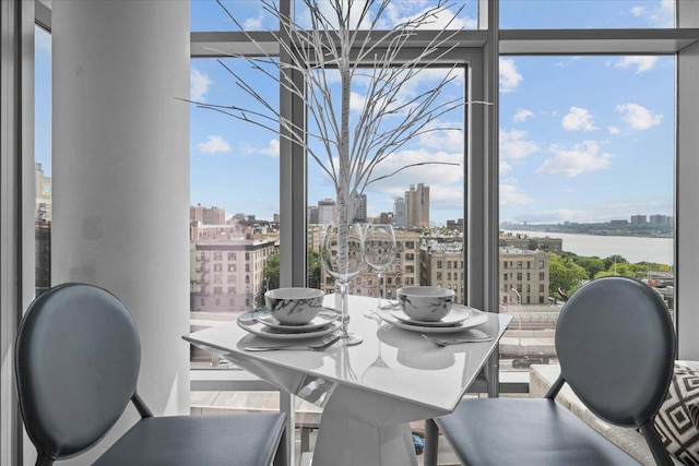 dining room with expansive windows and a water view